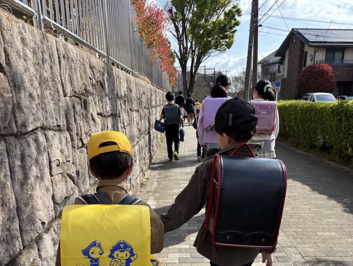 そうまくんが弟さんと手をつないで登校する後ろ姿